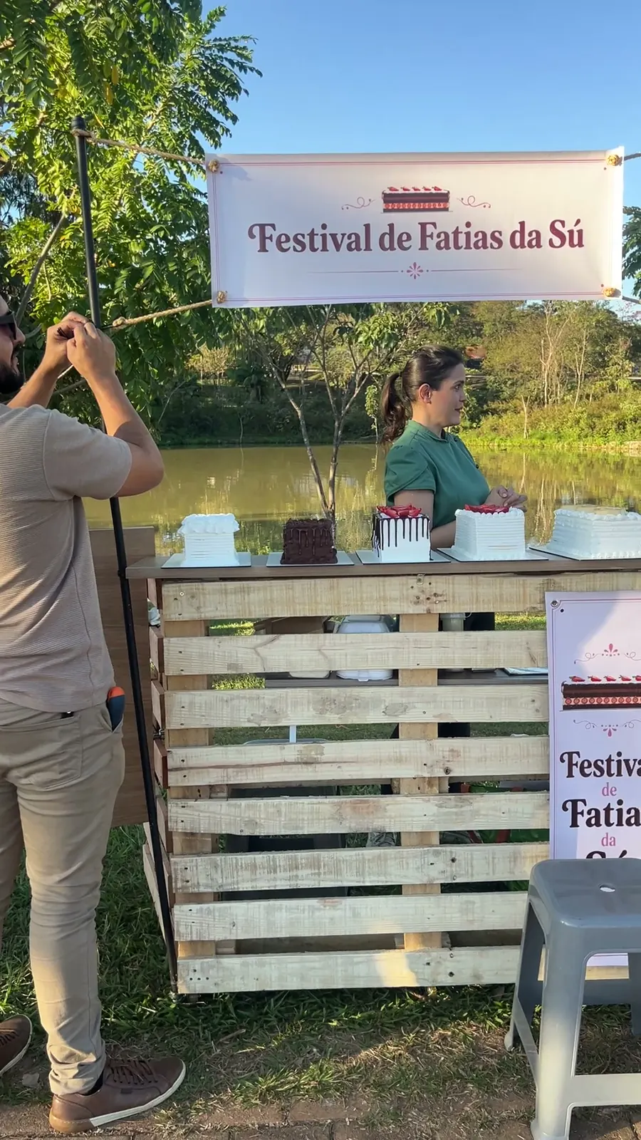 Puesto de pallets del Festival de Sú en un parque, con tortas y un cartel