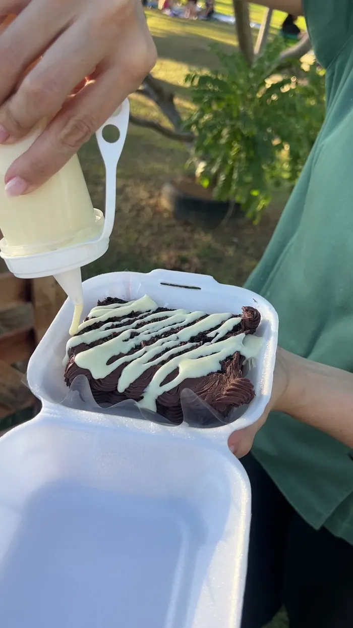 Porción de torta en su caja, con la salsa puesta en el momento